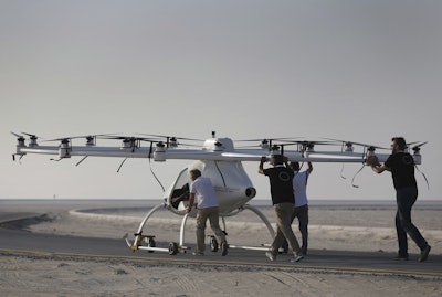 In this Sept. 26, 2017 photo, a Volocopter prototype is being pushed by their operators before it sets for a test fly in Dubai, United Arab Emirates, Tuesday, Sept. 26, 2017. Dubai is hoping to one day have flying, pilotless taxis darting among its skyscrapers. Just this week, the city-state in the United Arab Emirates hosted crews from the German company Volocopter, which had an electric, battery-powered two-seat prototype take off and land. Dubai hopes to have rules in place in the next five years to be ready for having the aircraft regularly flying through its skies. (AP Photo/Kamran Jebreili)