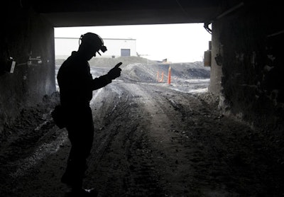 A mine employee stands in the entry of the Signal Peak Energy's Bull Mountain mine in Roundup, Mont. A judge has given a reprieve to the owners of the central Montana coal mine who had warned layoffs were imminent after the mine’s expansion plans were blocked. U.S. District Judge Donald Molloy said Tuesday, Oct. 31, 2017 that preparatory work in the expansion area can proceed while the mine’s climate change impacts are further studied. (AP Photo/Janie Osborne,File)