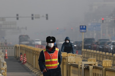 In this Jan 4, 2017 file photo a traffic warden wearing a protection mask walks on a street near Tiananmen Square in Beijing as the capital of China is blanketed by heavy smog. World leaders arrive at the global climate talks in Germany on Wednesday, Nov. 15, 2017 to give the negotiations a boost going into the final stretch. (AP Photo/Andy Wong, file)