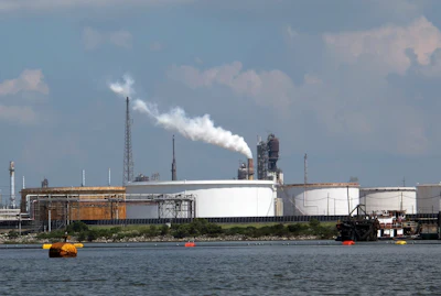 This Friday, Oct. 13, 2017, photo taken from upper Galveston Bay shows the Exxon Mobil Baytown refinery and chemical plant in Baytown, Texas. On Tuesday, Oct. 31, 2017, federal officials said that Exxon Mobil settled violations of the clean-air law with the Trump administration by agreeing to pay a $2.5 million civil penalty and spend $300 million on pollution-control technology at plants along the Gulf Coast. The plants are in Baytown, Beaumont and Mont Belvieu, Texas, and Baton Rouge, Louisiana. As part of the settlement, Exxon will spend $1 million to plant trees in Baytown. (AP Photo/Frank Bajak)