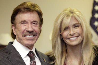 In this Dec. 2, 2010 file photo, actor Chuck Norris, left, and his wife Gena pose for a photo following a ceremony in Garland, Texas. Norris is taking on medical device manufacturers in a lawsuit alleging a chemical used in MRI imaging scans poisoned his wife. The lawsuit filed on Wednesday, Nov. 1, 2017, in San Francisco says gadolinium that doctors injected into Gena Norris to improve the clarity of her MRIs have left her weak and tired and with debilitating bouts of pain and a burning sensation. (AP Photo/Tony Gutierrez, File)