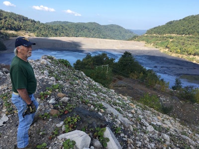 In this Tuesday, Sept. 26, 2017 photo, former coal miner Chuck Nelson looks out on the Brushy Fork impoundment in Raleigh County, in southern West Virginia, an estimated 7.8 billion gallon coal slurry containing sludge and chemicals from nearby surface mines. He says the slurries pollute the groundwater and contribute to high rates of cancer and other illnesses among the people living nearby. (AP Photo/Michael Virtanen)