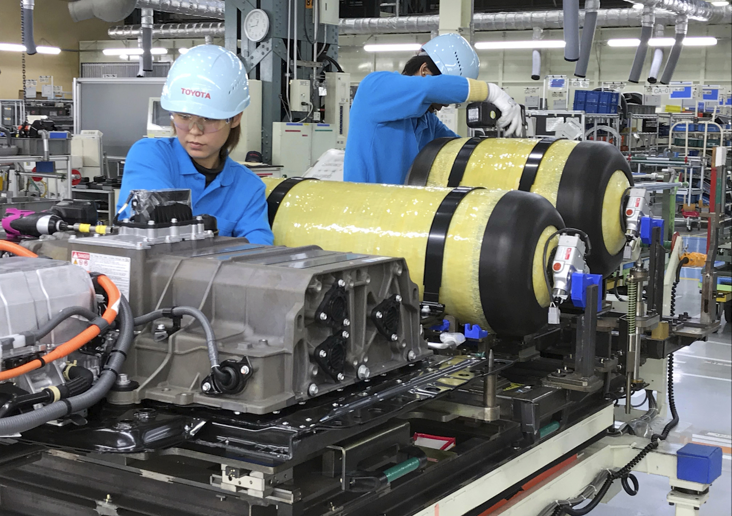 In this Oct. 30, 2017, photo, workers of Toyota Motor Corp. set hydrogen-stored tanks, in yellow, to be placed into a Mirai fuel cell vehicle at the automaker's Motomachi plant, in Toyota, western Japan. Toyota is banking on a futuristic “electrification” auto technology called hydrogen fuel cells for its zero-emissions option. The Associated Press got a tour of Toyota’s Motomachi plant that assembles the Mirai fuel cell vehicle. (AP Photo/Yuri Kageyama)