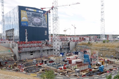 In this Sept. 15, 2016 file photo, cranes stand at the construction site of the ITER ( the International Thermonuclear Experimental Reactor) in Cadarache, southern France. A vast international experiment designed to demonstrate that nuclear fusion can be a viable source of clean and cheap energy is halfway toward completion. The organization behind the ITER announced the milestone Wednesday Dec. 6, 2017 and confirmed it's aiming to conduct a first test run in 2025. (AP Photo/Claude Paris, File)
