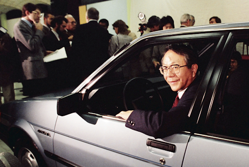 United Motor Manufacturing Co. President Tatsuro Toyoda gets in the drivers seat of the newly unveiled sporty 4-door subcompact 'Nova' in the new Fremont, Calif., United Motor Manufacturing Co. plantjointly jowned by General Motors and Toyota. Toyoda, a former president of Toyota Motor Corp., who led its climb to rank among the world’s top automakers, and the son of the Japanese automaker’s founder, has died. He was 88. (Toyota Motor Corp. via AP)(AP Photo/Paul Sakuma)