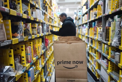 In this Wednesday, Dec. 20, 2017, file photo, a clerk reaches to a shelf to pick an item for a customer order at the Amazon Prime warehouse, in New York. Amazon announced Thursday, Jan. 18, 2018, that it has narrowed down its potential site for a second headquarters in North America to 20 metropolitan areas, mainly on the East Coast. (AP Photo/Mark Lennihan, File)