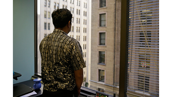 FILE - In this Sept. 22, 2016, file photo, Sorihin, who uses one name, one of two Indonesian fisherman who escaped slavery aboard a U.S.-flagged tuna and swordfish vessel when it docked at San Francisco's Fisherman's Wharf, looks out toward Montgomery Street at the offices of the Legal Aid Society in San Francisco. Attorneys for Sorihin and Abdul Fatah told The Associated Press on Wednesday, Jan. 3, 2018, that they settled their lawsuit against Thoai Van Nguyen, the California-based owner and captain of the Sea Queen II. (AP Photo/Eric Risberg, File)