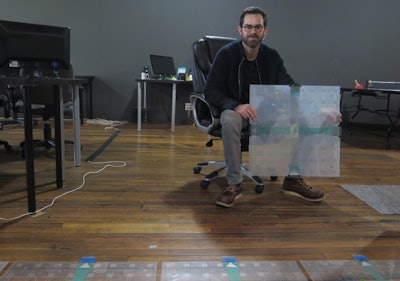 In this photo taken Dec. 5, 2017, Scanalytics co-founder and CEO Joe Scanlin holds a smart floor sensor his company creates that track people's movements in Milwaukee. The sensors are among the tools retailers are using to gain insights on consumer habits. (AP Photo/Ivan Moreno)