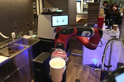 Robot barista named 'Sawyer' makes a coffee at Henn-na Cafe in Tokyo. The cafe's robot barista brews and serves coffee as the rapidly aging country seeks to adapt to shrinking workforce. (AP Photo/Koji Sasahara)