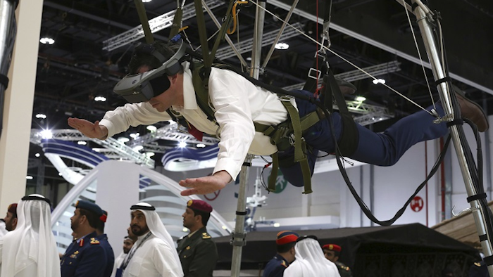 A visitor to a drone conference tries out a parachute simulator in Abu Dhabi, United Arab Emirates, Sunday, Feb. 25, 2018. Image credit: AP Photo/Jon Gambrell