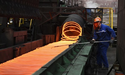 vIn this March 5, 2018 photo, a worker manipulates coils of steel at Xiwang Special Steel in Zouping County in eastern China's Shandong province. Image credit: Chinatopix via AP