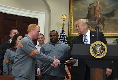 President Donald Trump reaches out to shake the hand of Dusty Stevens, a superintendent at Century Aluminum Potline, during an event in the Roosevelt Room of the White House in Washington, Thursday, March 8, 2018. Image credit: AP Photo/Susan Walsh