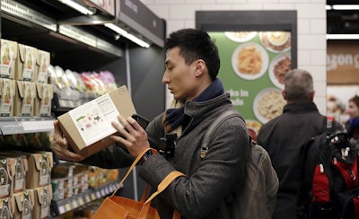 In this Jan. 22, 2018, file photo, customer Paul Fan shops at an Amazon Go store in Seattle. Image credit: AP Photo/Elaine Thompson, File