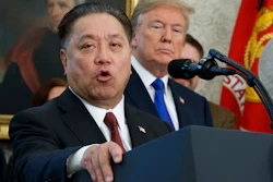 In this Thursday, Nov. 2, 2017, file photo, Broadcom CEO Hock Tan speaks while U.S. President Donald Trump listens, in background, during an event at the White House in Washington, to announce the company is moving its global headquarters to the United States. Image credit: AP Photo/Evan Vucci, File