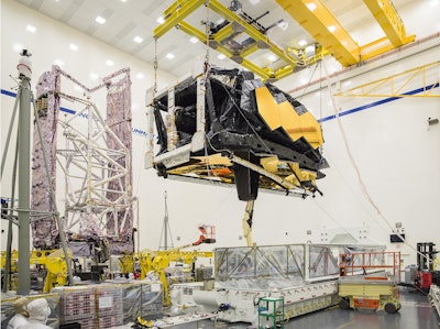 Engineers lift the combined optics and science instruments of NASA’s James Webb Space Telescope after removing it from the Space Telescope Transporter for Air, Road and Sea (STTARS) at Northrop Grumman in Redondo Beach, California, on March 8, 2018. Image credit: NASA/Chris Gunn