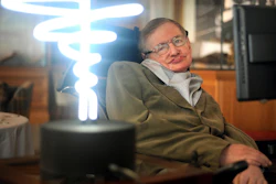 In this Feb. 25, 2012 photo, Professor Stephen Hawking poses beside a lamp titled 'black hole light' by inventor Mark Champkins, presented to him during his visit to the Science Museum in London. Image credit: Anthony Devlin/PA via AP