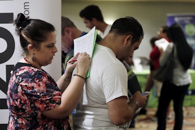 In this Jan. 30, 2018 photo, Loredana Gonzalez, of Doral, Fla., fills out a job application at a JobNewsUSA job fair in Miami Lakes, Fla. Image credit: AP Photo/Lynne Sladky