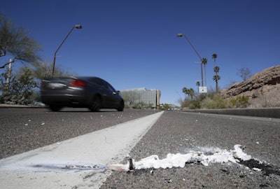 A vehicle goes by the scene of Sunday's fatality where a pedestrian was stuck by an Uber vehicle in autonomous mode, in Tempe, Ariz., Monday, March 19, 2018. Image credit: AP Photo/Chris Carlson
