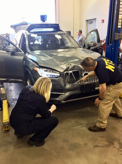 In this March 20, 2018, photo provided by the National Transportation Safety Board, investigators examine a driverless Uber SUV that fatally struck a woman in Tempe, Ariz. Image credit: National Transportation Safety Board via AP