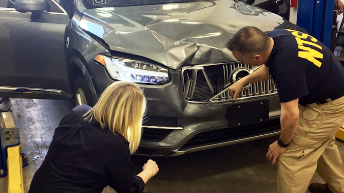 In this March 20, 2018, photo provided by the National Transportation Safety Board, investigators examine a driverless Uber SUV that fatally struck a woman in Tempe, Ariz. Image credit: National Transportation Safety Board via AP