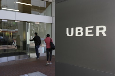 In this March 1, 2017 file photo, people enter the headquarters of Uber in San Francisco. Uber suspended all of its self-driving testing Monday, March 19, 2018, after what is believed to be the first fatal pedestrian crash involving the vehicles. Image credit: AP Photo/Eric Risberg, File
