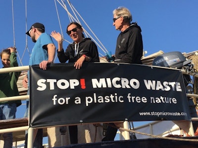 In this Oct. 15, 2017, photo provided by Alexander Nolte, Marta Delgado, center, and Joseph Dillard, right, participate in an event to raise awareness about microfiber pollution in the environment in Amsterdam, Netherlands. Innovators are coming up with new tools to prevent tiny pieces of threads from entering waterways after the laundry and reaching marine life. (Alexander Nolte via AP)