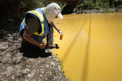 In this Aug. 6, 2015 file photo, Dan Bender, with the La Plata County Sheriff's Office, takes a water sample from the Animas River near Durango, Colo. after the accidental released of an estimated 3 million gallons of waste from the Gold King Mine by a crew led by the Environmental Protection Agency. The EPA says it has almost finished reviewing hundreds of damage claims from the spill, but the agency has still not released a clear accounting of the claims made for economic losses and personal injuries. (Jerry McBride /The Durango Herald via AP, File)