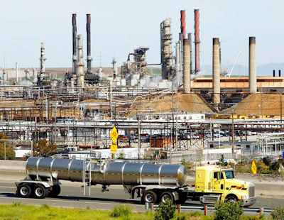 This March 9, 2010 file photo shows a tanker truck passing the Chevron oil refinery in Richmond, Calif. A federal judge presiding over lawsuits accusing big oil companies of lying about global warming is turning his courtroom into a classroom. U.S. District Judge William Alsup has asked lawyers for two California cities and five of the world's largest oil and gas companies to come to court on Wednesday, March 21, 2018 to present 'the best science now available on global warming.' (AP Photo/Paul Sakuma, File)