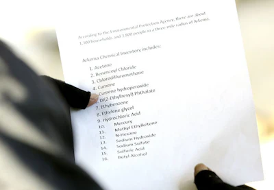 In this Nov. 11, 2017 photo, a resident of Crosby, Texas, holds a list of chemicals present at the Arkema plant that was passed around to people who live near the chemical plant. (Elizabeth Conley/Houston Chronicle via AP)