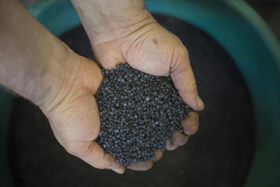 In this Tuesday, March 13, 2018 photo, a worker holds bio-based thermoplastic composite made from substantially unsorted municipal solid waste material in the UBQ factory in Kibbutz Zeelim. Israeli start-up UBQ says its innovative method to convert garbage into plastics, five years in the making, will revolutionize waste management worldwide and make landfills obsolete. (AP Photo/Ariel Schalit)
