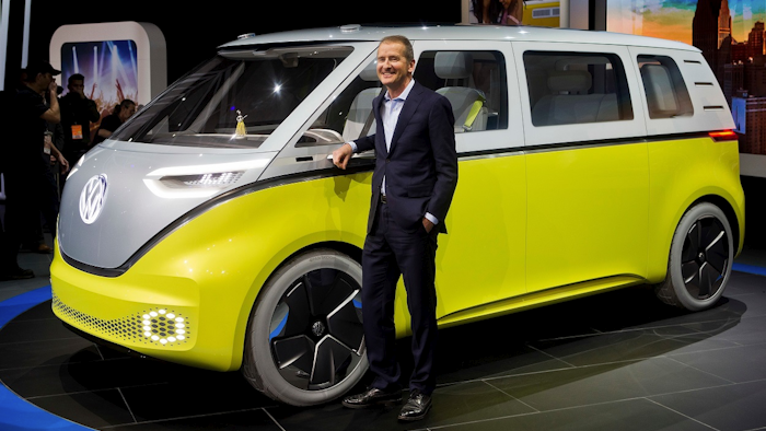 In a Jan. 9, 2017, file photo, Herbert Diess, chairman of the Volkswagen brand, poses with the I.D. Buzz all-electric concept van, at the North American International Auto Show, in Detroit. Image credit: AP Photo/Tony Ding, File