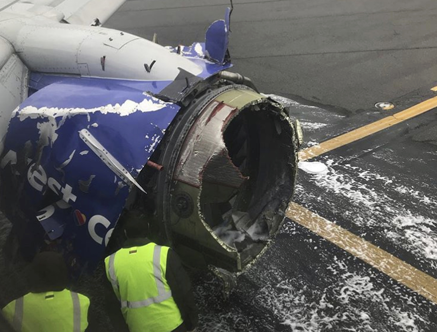 The engine on a Southwest Airlines plane is inspected as it sits on the runway at the Philadelphia International Airport after it made an emergency landing in Philadelphia, Tuesday, April 17, 2018. (Amanda Bourman via AP)