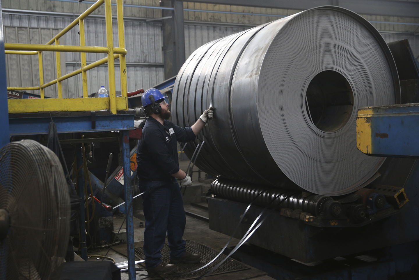 Zach Davis straps down a steel coil at the Borusan Mannesmann steel pipe plant in Baytown, Texas, Monday, April 23, 2018. President Donald Trump's escalating dispute with China over trade and technology is threatening jobs and profits in working-class communities where his 'America First' agenda hit home. Without a waiver, Borusan Mannesmann Pipe may face tariffs of $25 million to $30 million annually if it imports steel tubing and casing from its parent company in Turkey, according to information the company provided to The Associated Press. (AP Photo/Loren Elliott)