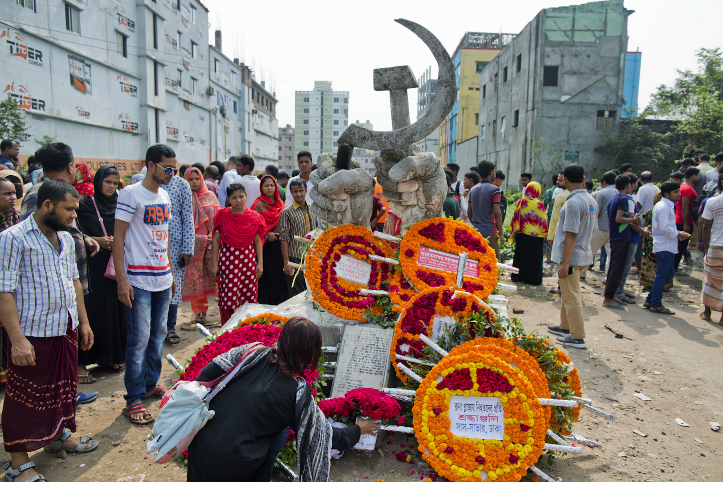Bangladeshis offer flowers to a monument erected in memory of victims of a garment factory collapse as they gather at the site on the fifth anniversary of the accident in Savar, near Dhaka, Bangladesh, Tuesday, April 24, 2018. The tragedy killed 1,134 people, many of them young women supporting extended families, and injured more than 2,500. (AP Photo/A.M. Ahad)