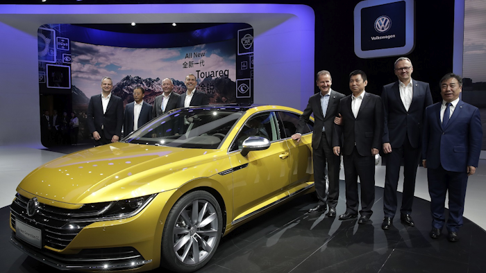 Herbert Diess, CEO of Volkswagen, fourth from right, poses with officials and the newly unveiled Volkswagen CC car model during the media day of the China Auto Show in Beijing, Wednesday, April 25, 2018. Image credit: AP Photo/Andy Wong
