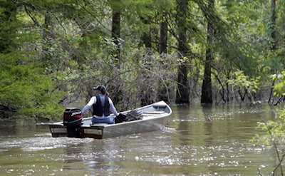 In this Friday, April 27, 2018 photo, a local craw fisherman motors her boat on Bayou Sorrel in the Atchafalaya River Basin in Louisiana. A company building a crude oil pipeline in Louisiana is asking a federal appeals court to throw out a judge's order that had suspended construction work in an environmentally fragile swamp. A three-judge panel of the 5th U.S. Circuit Court of Appeals is scheduled to hear arguments Monday, April 30, by attorneys for Bayou Bridge Pipeline LLC, federal regulators and environmental groups opposed to the project. In February, a judge temporarily stopped all pipeline construction work in the Atchafalaya Basin. (AP Photo/Gerald Herbert)