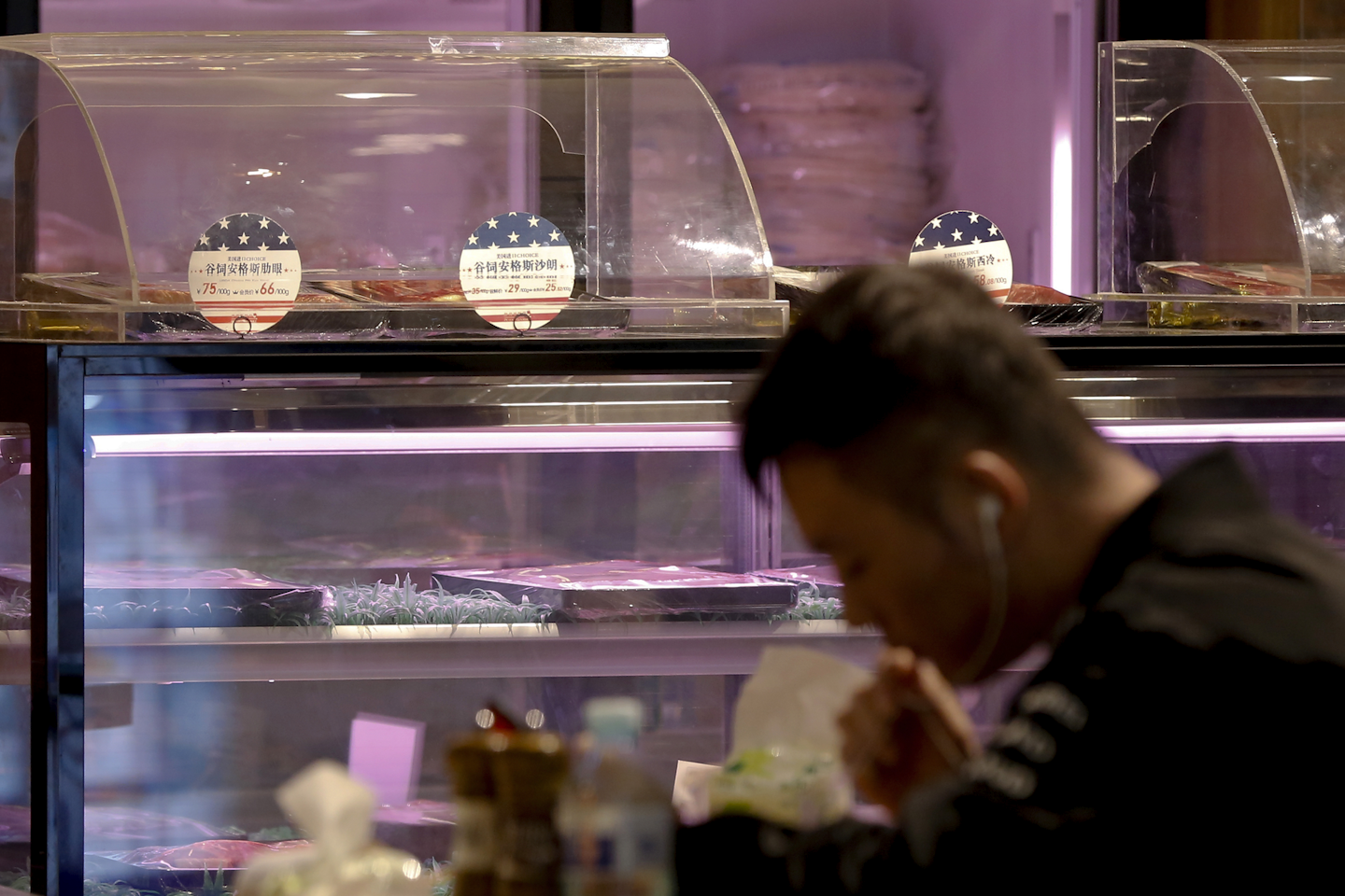 A man eats at a restaurant serving imported American beefs at a shopping mall in Beijing, Thursday, April 5, 2018. The United States and China, the world's two largest economies, have roiled financial markets and fueled fears of a protracted trade war by threatening tariffs this week on each other's goods. The United States on Tuesday said it would impose 25 percent duties on $50 billion of imports from China, and China quickly retaliated by listing $50 billion of products that it could hit with its own 25 percent tariffs. (AP Photo/Andy Wong)