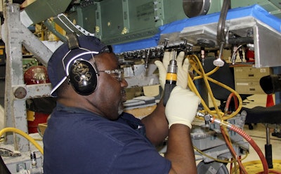 In this Wednesday, April 25, 2018, photo, steam metal assembly riveter Lay Johnson works on an F/A-18 at Boeing's fighter aircraft production line in St. Louis. Image credit: AP Photo/Ted Shaffrey