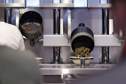 Customers wait as their automatically prepared food is dropped from a cooking pot into a bowl at Spyce, a restaurant which uses a robotic cooking process in Boston, Thursday, May 3, 2018. Image credit: AP Photo/Charles Krupa