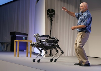 In this July 20, 2017 file photo, Boston Dynamics Chief Executive Marc Raibert speaks about his four-legged robot SpotMini during a SoftBank World presentation at a hotel in Tokyo. Image credit: AP Photo/Shizuo Kambayashi, File