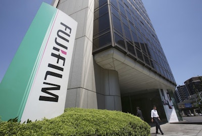 People walk out of Nishiazabu headquarters of Fujifilm Holdings Corporation in Tokyo, Monday, May 14, 2018. Image credit: AP Photo/Koji Sasahara