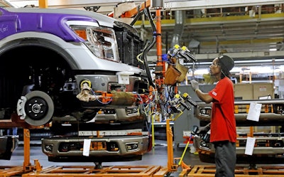 In this March 19, 2018, file photo, a line technician positions a truck front bumper for assembly at the Nissan Canton Assembly Plant, in Canton, Miss. Image credit: AP Photo/Rogelio V. Solis, File