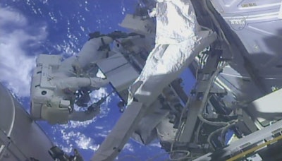 In this frame from NASA TV, NASA astronaut Ricky Arnold, left, and NASA astronaut Drew Feustel work on shuffling around a couple of space station pumps at the International Space Station on Wednesday, May 16, 2018. Image credit: NASA TV via AP