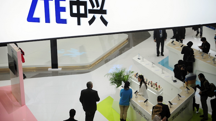 In this Feb. 26, 2014, file photo, people gather at the ZTE booth at the Mobile World Congress, the world's largest mobile phone trade show in Barcelona, Spain. Image credit: AP Photo/Manu Fernandez, File