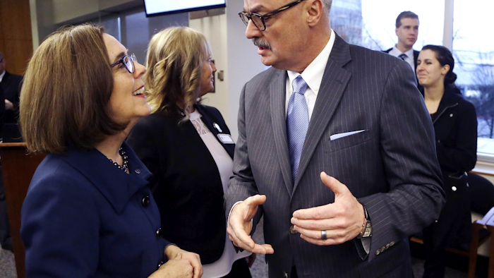 In this Feb. 2, 2018, file photo, U.S. Attorney for the District of Oregon Billy J. Williams, right, talks with Oregon Gov. Kate Brown before the start of a marijuana summit in Portland, Ore. Image credit: AP Photo/Don Ryan, file