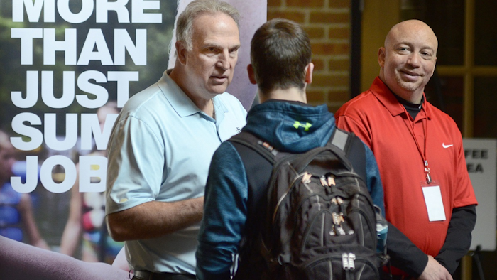 In this March 14, 2018, file photo, Dan Cieslak, left, a Human Resources representative for the Dunham's Distribution Center, and Warren Whitlow, a training manager, speak to students and other visitors during the Experience Indiana job fair event in the student center at Indiana Wesleyan University in Marion, Ind. Image credit: Jeff Morehead/The Chronicle-Tribune via AP, File