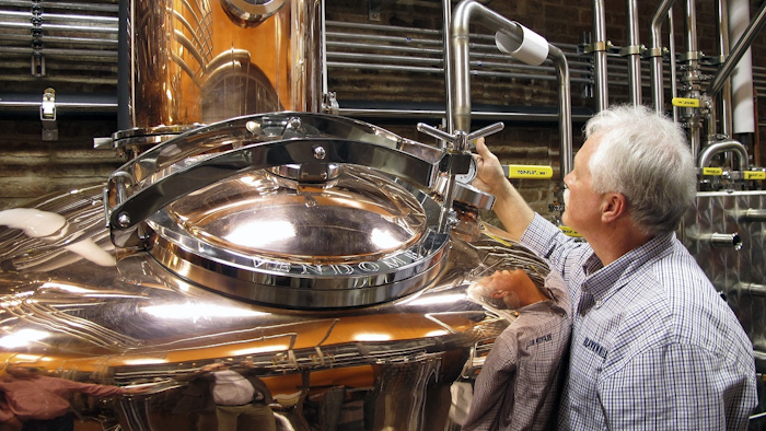 In this Wednesday Nov. 13, 2013, file photo, Charlie Downs, the artisanal craft distiller at a new Heaven Hill Distilleries, Louisville, Ky., checks gauges on a still that will produce small batches of whiskey. Image credit: AP Photo/Bruce Schreiner, File