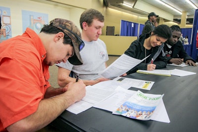 In this Feb. 8, 2018, file photo, Garrett Thornton, left, Bradley Harper, Heather Wood and Marcus Brown fill out various job applications at the Governor's Job Fair in the Tommy E. Dulaney Center in Meridian, Miss. Image credit: Paula Merritt/The Meridian Star via AP, File