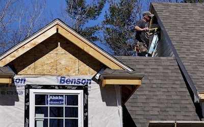 In this April 23, 2018, file photo, a worker installs vinyl siding on a new home in Auburn, N.H. Image credit: AP Photo/Charles Krupa, File