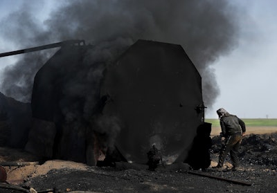 In this April 6, 2018 file photo, a former farmer works at a primitive refinery as he makes crude oil into diesel and other products, in Rmeilan, Hassakeh province, Syria. Image credit: AP Photo/Hussein Malla, file